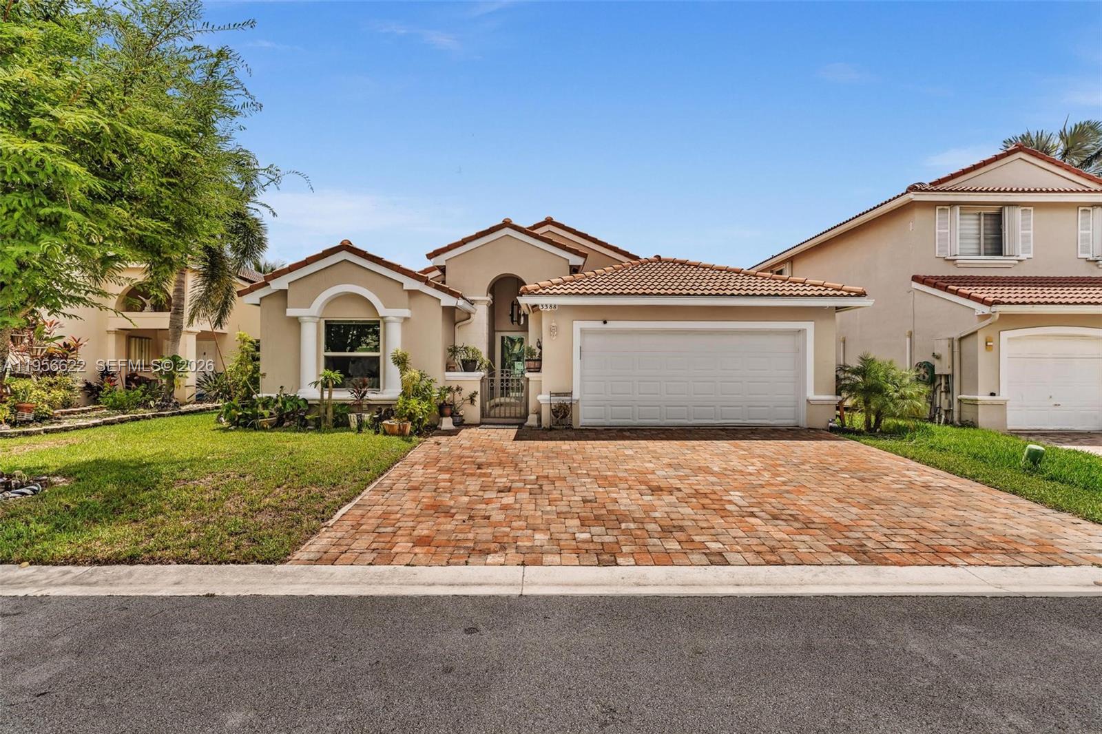 A single-story house with a tiled roof, beige stucco exterior, and a brick paver driveway — 3388 SW 49th St, Hollywood FL 33312, HOLLYWOOD, FL