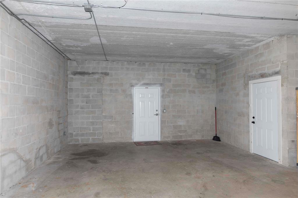 An unfinished garage with exposed concrete block walls, a concrete floor, and two white doors — 4751 W MARINE PARKWAY UNIT 4751, NEW PORT RICHEY, FL