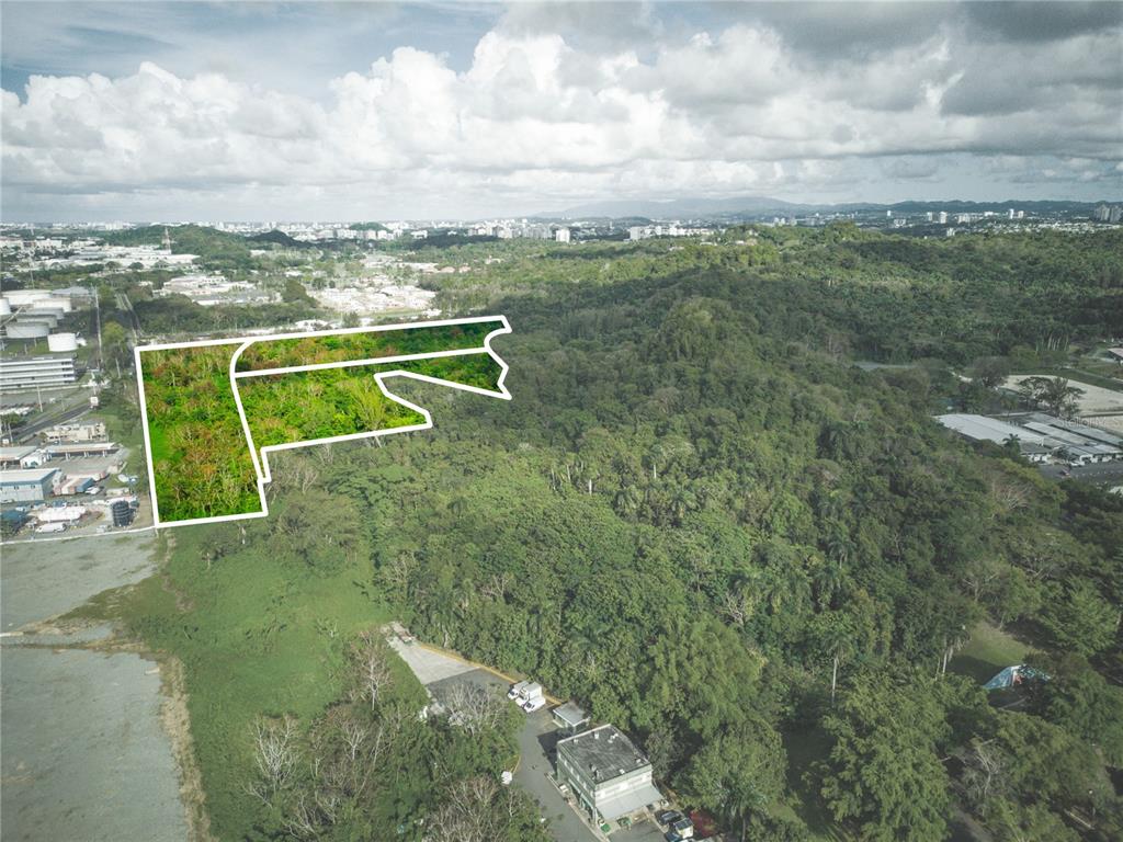 An aerial view shows a plot of land outlined in white against a forested landscape — CARRETERA 2, KM 3.1, BAYAMON, PR