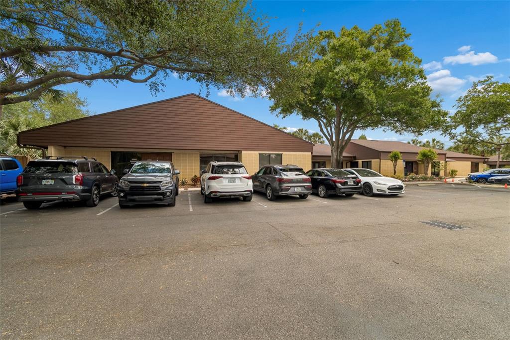 A low-rise commercial building with a brown roof and parking lot in front — 611 DRUID ROAD E UNIT 101-110, CLEARWATER, FL