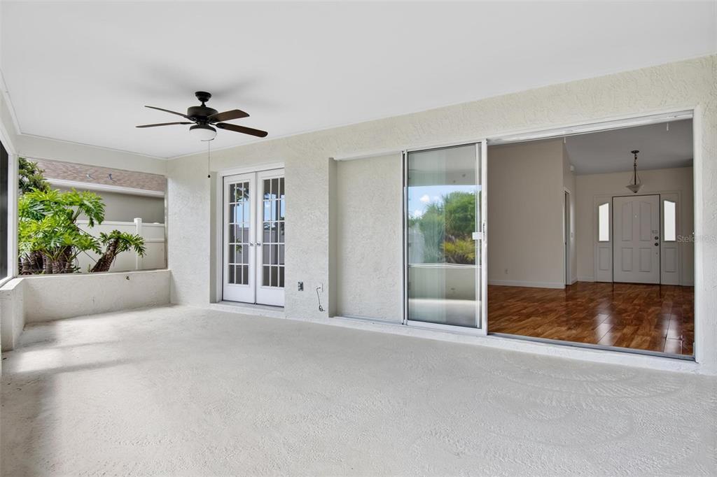 A covered patio with a ceiling fan, sliding glass doors, and a view of the interior — 231 WELLINGTON DRIVE, PALM COAST, FL