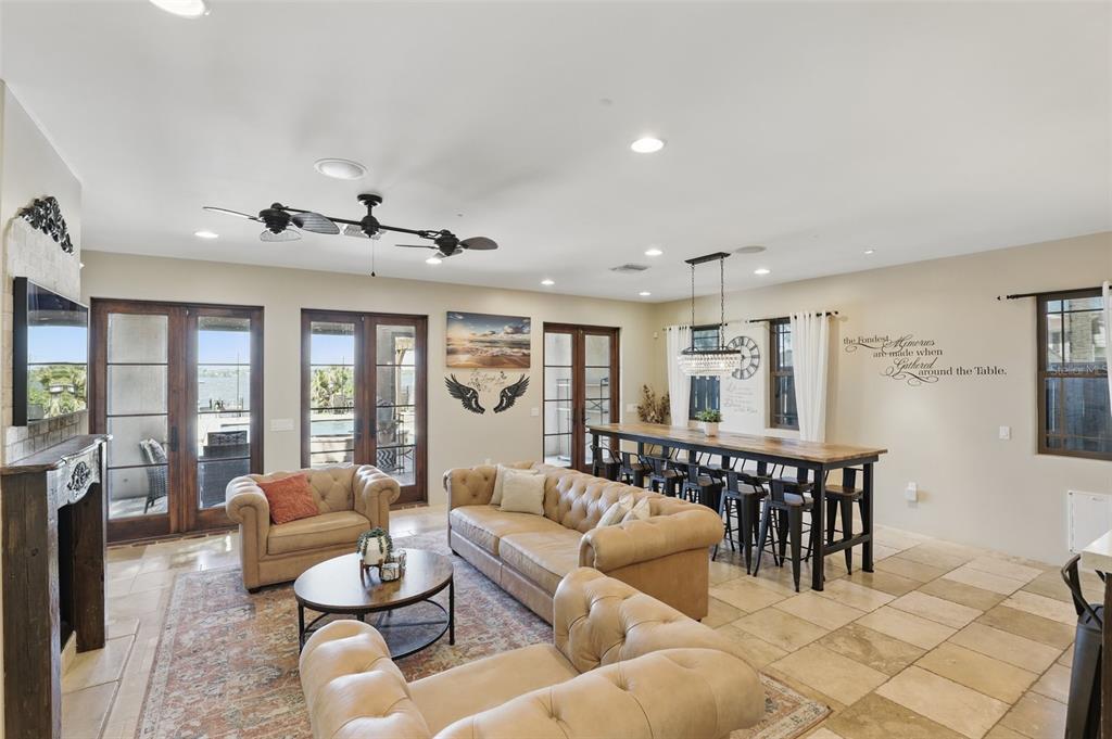 A living and dining area features tan leather furniture, a long wooden table, and tile floors — 106 VICTORIA STREET, MERRITT ISLAND, FL
