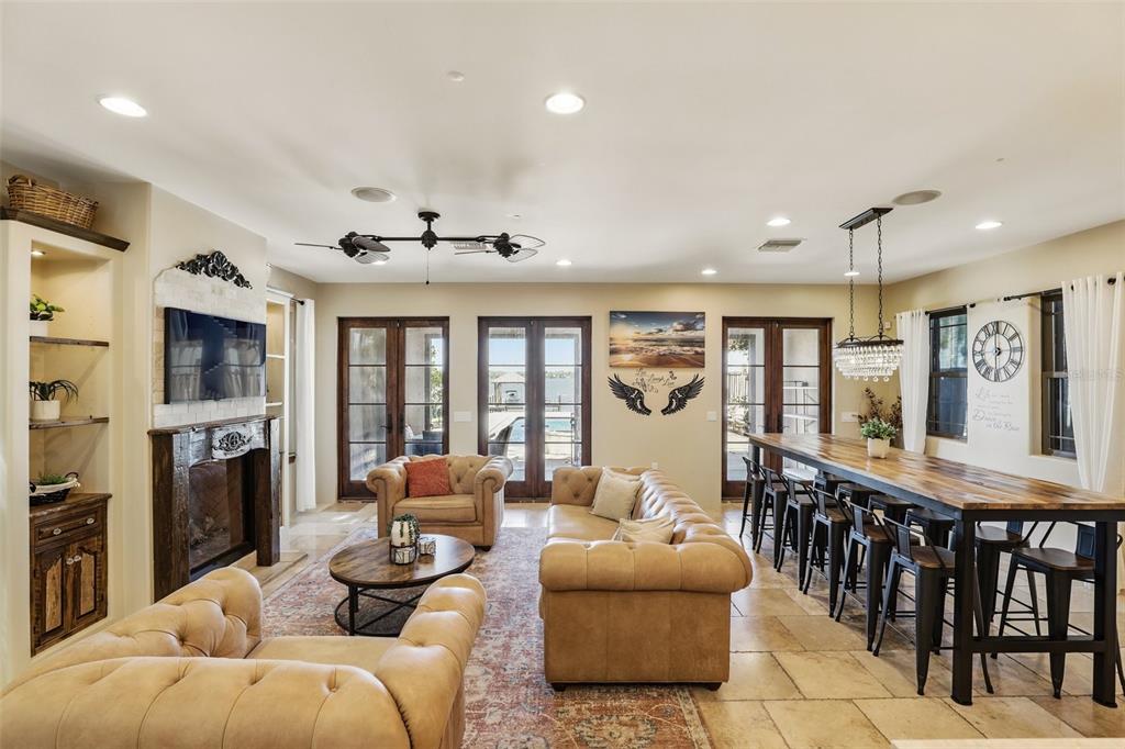 A living room features a fireplace, tufted leather furniture, and a long dining table — 106 VICTORIA STREET, MERRITT ISLAND, FL