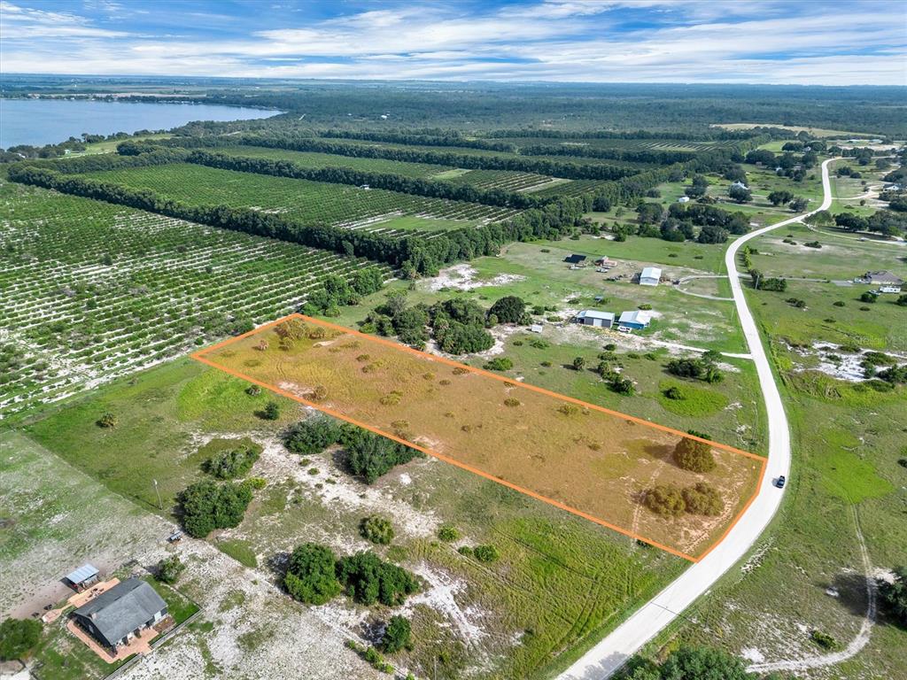 An aerial view shows a rectangular plot of land outlined in orange next to a road — 2478 OLD GROVE TRAIL, FROSTPROOF, FL