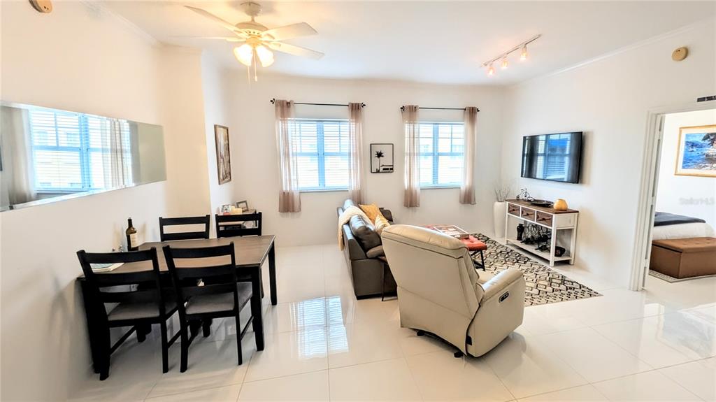 A bright living and dining area with white tile floors, a ceiling fan, and furniture — 1064 N TAMIAMI TRAIL UNIT 1606, SARASOTA, FL