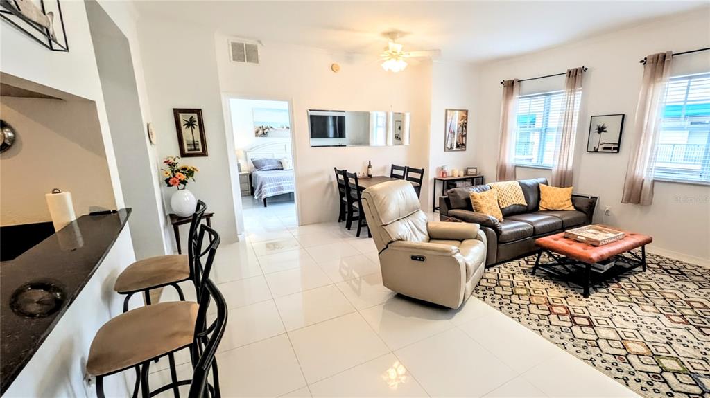 A living room features a beige recliner, a brown sofa, and a breakfast bar — 1064 N TAMIAMI TRAIL UNIT 1606, SARASOTA, FL