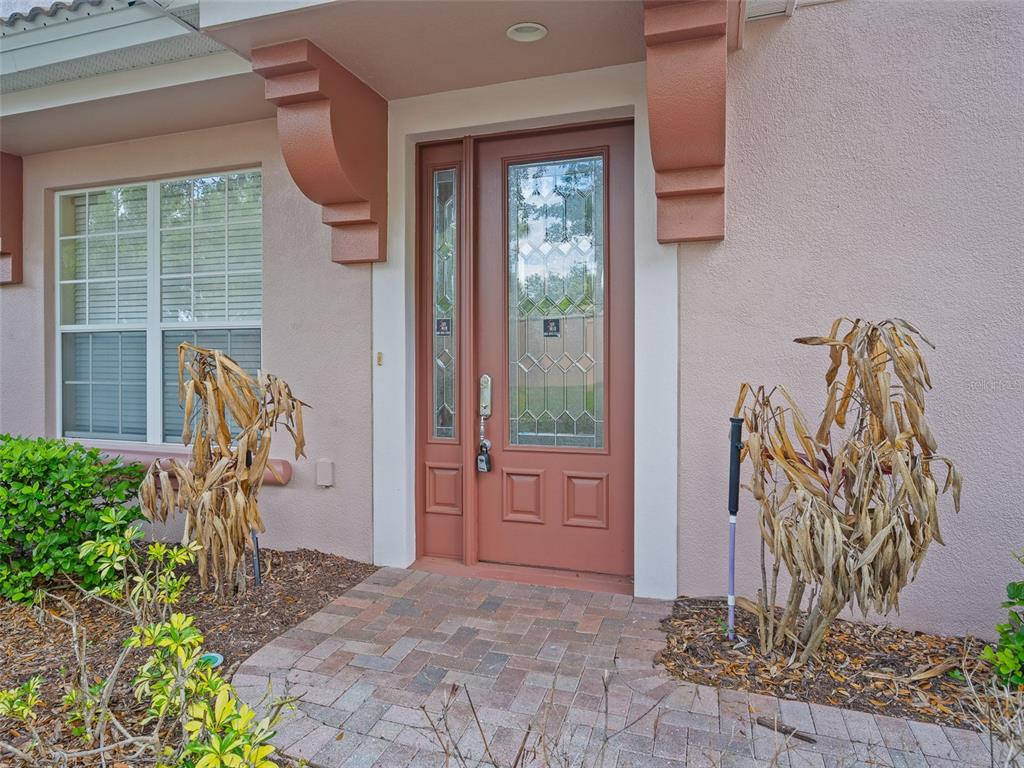 A front entryway features a brown door with a glass insert and brick paver walkway — 1409 MILLEDGE LANE UNIT 1409, DAVENPORT, FL