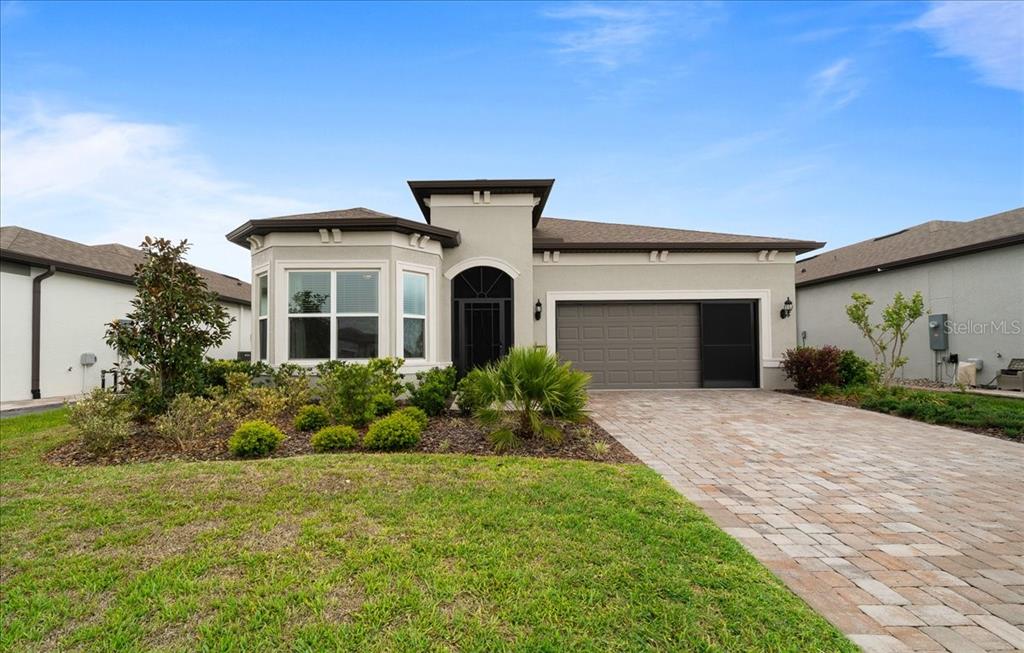 A single-story house with a paved driveway, a two-car garage, and a bay window — 8750 SW 59TH LANE ROAD, OCALA, FL