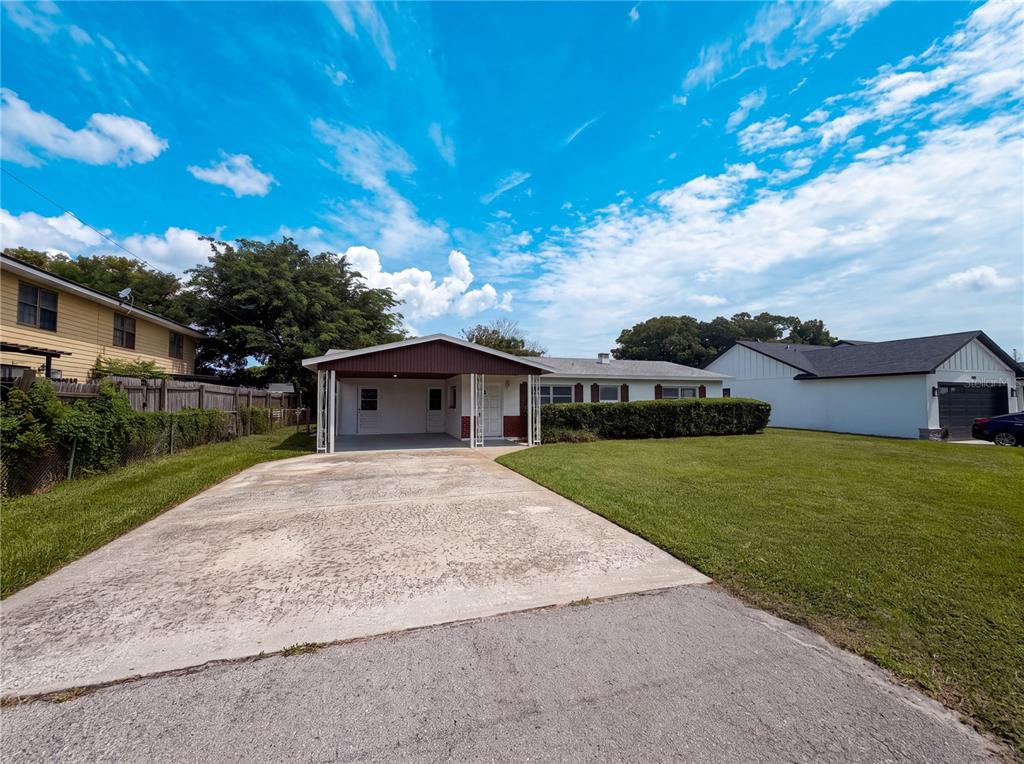 A single-story house with a carport, concrete driveway, and a large front lawn — 1804 AVENUE Q SW, WINTER HAVEN, FL