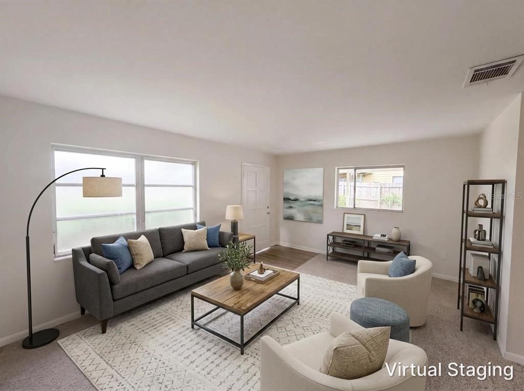 A virtually staged living room with a gray sofa, two armchairs, and a coffee table — 1804 AVENUE Q SW, WINTER HAVEN, FL