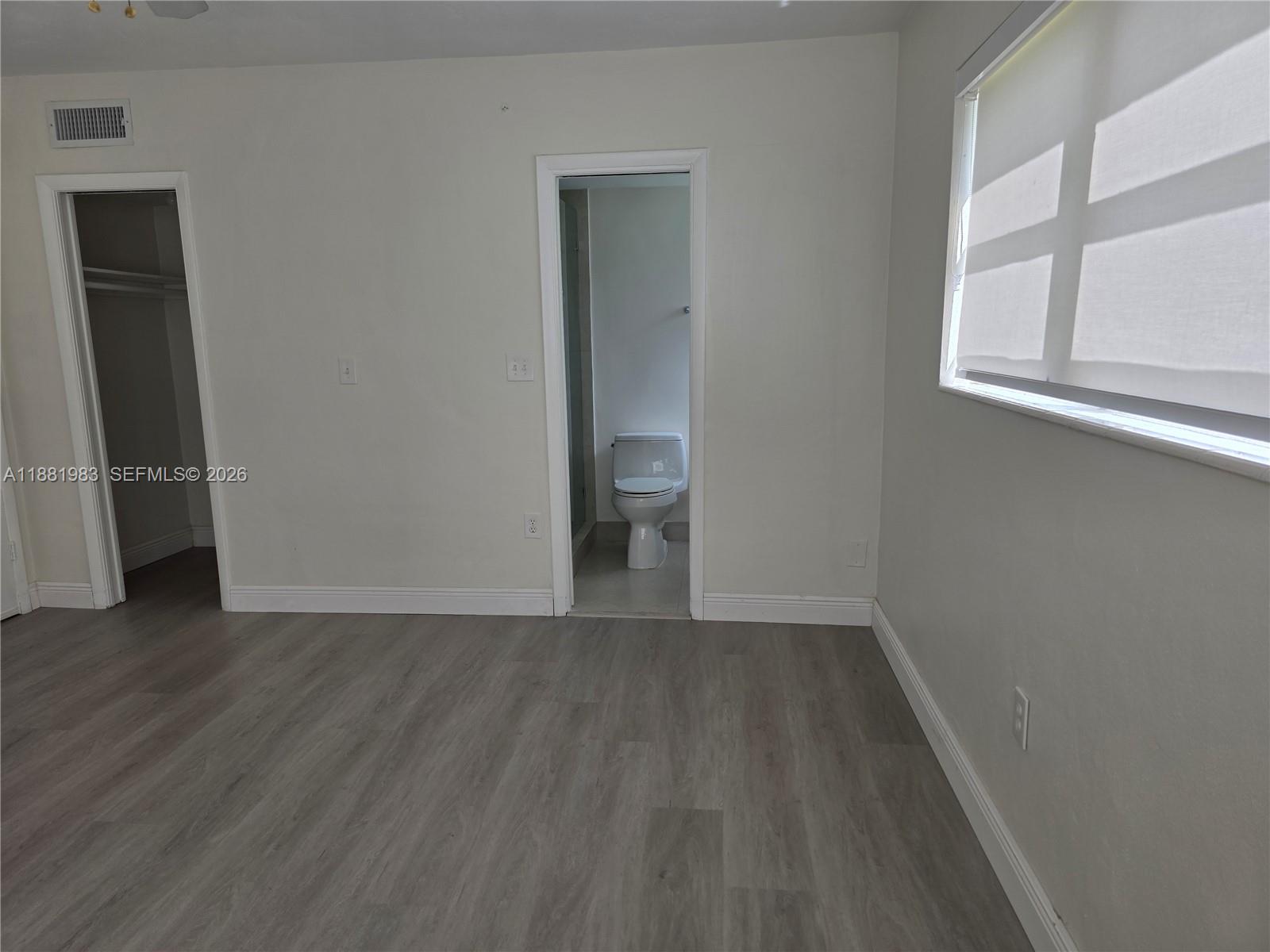 A modern kitchen features white cabinets, a marble-topped peninsula, and stainless steel appliances — 18720 NE 18th Ave # 116, Miami FL 33179, MIAMI, FL