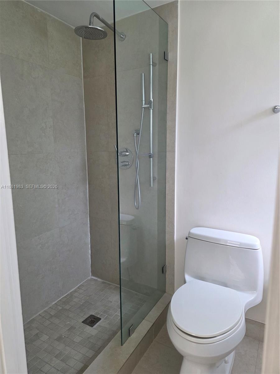 A closet features white louvered doors, built-in shelving, and a five-drawer white dresser — 18720 NE 18th Ave # 116, Miami FL 33179, MIAMI, FL
