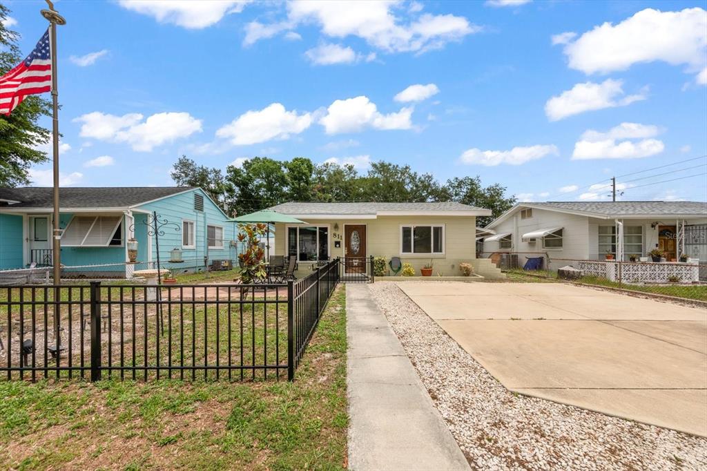 A single-story house with a concrete driveway, a front yard, and a black metal fence — 811 48TH AVENUE N, ST PETERSBURG, FL