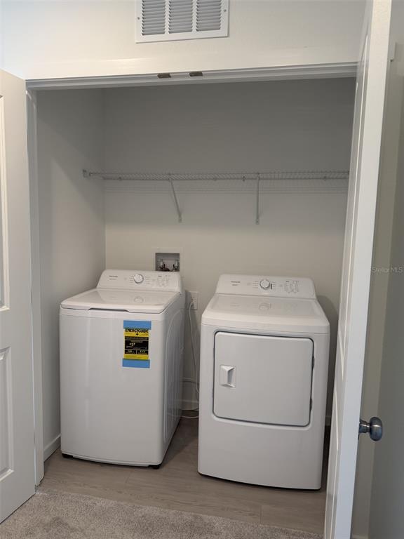 A laundry closet contains a white top-loading washing machine and a matching clothes dryer — 1219 ORION STREET, DAVENPORT, FL