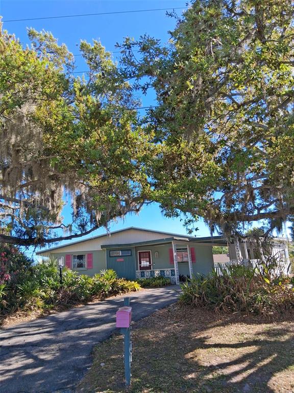 A single-story house with a pink mailbox and shutters sits under large oak trees — 3372 MAYFLOWER STREET, SARASOTA, FL