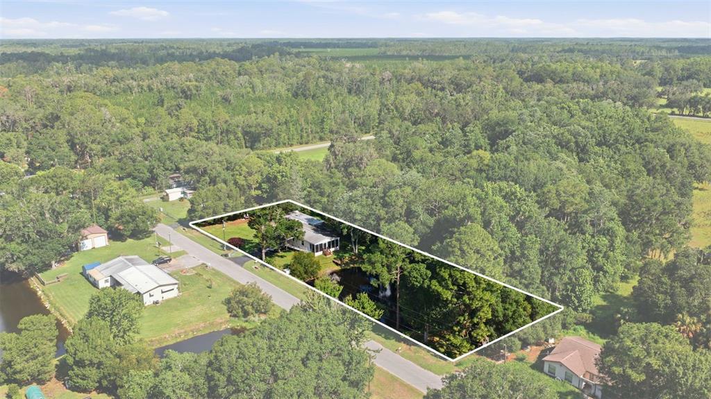 An aerial view shows a house on a rectangular lot surrounded by dense forest — 22925 SW 117TH STREET, DUNNELLON, FL