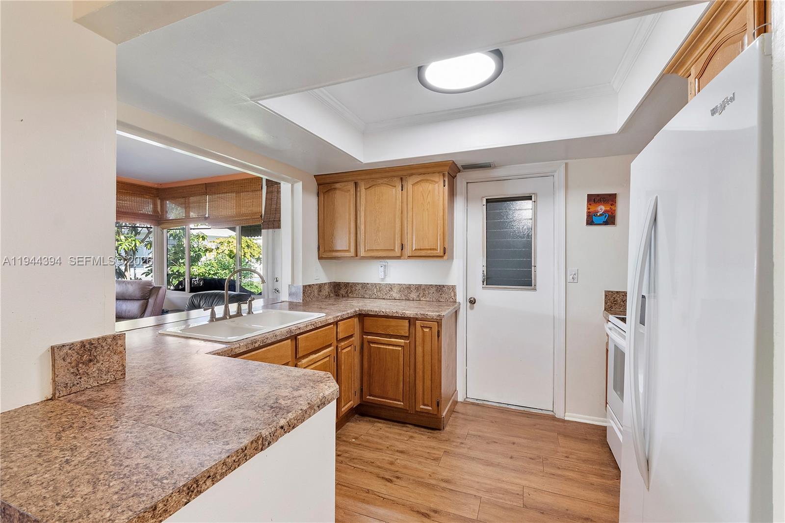 A dining area features a dark wood table with chairs and a bench on tile flooring — 5011 NW 51st St, Tamarac FL 33319, TAMARAC, FL