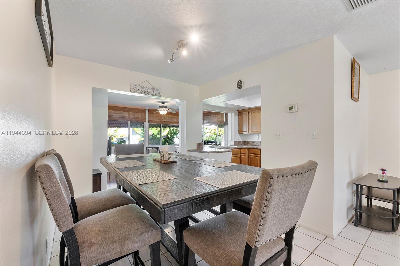 A bathroom features a wooden vanity with a granite countertop and a floral shower curtain — 5011 NW 51st St, Tamarac FL 33319, TAMARAC, FL