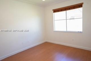 An empty room with white walls, light wood-style flooring, and a window with wooden blinds — 7070 NW 177th St # 10, Hialeah FL 33015, HIALEAH, FL
