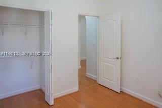 An interior view shows a closet with open doors, a doorway, and light wood flooring — 7070 NW 177th St # 10, Hialeah FL 33015, HIALEAH, FL