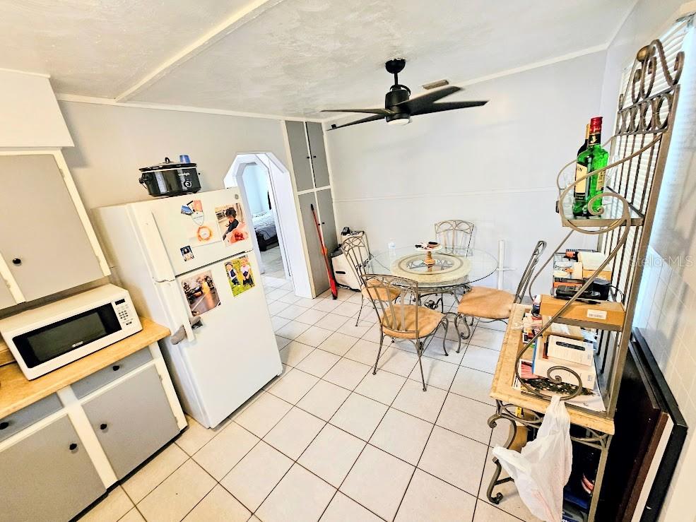 A kitchen with white cabinets, a refrigerator, a glass dining table, and tile flooring — 1500 S MARTIN LUTHER KING JR AVENUE, CLEARWATER, FL