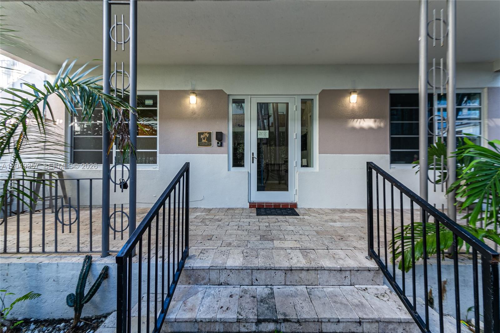 The exterior entrance features stone steps, black metal railings, and a glass front door — 1431 Lincoln Ter # 1, Miami Beach FL 33139, MIAMI BEACH, FL