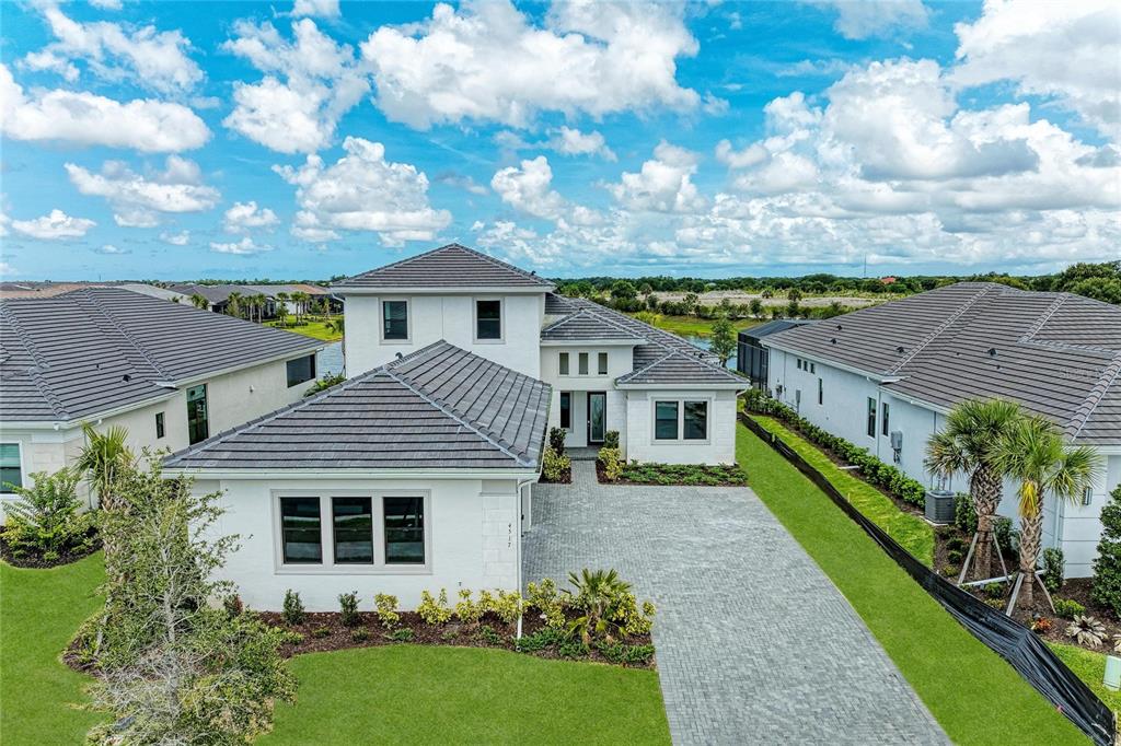 A two-story white house with a gray tile roof and a paved driveway — 4517 MONDRIAN COURT, SARASOTA, FL