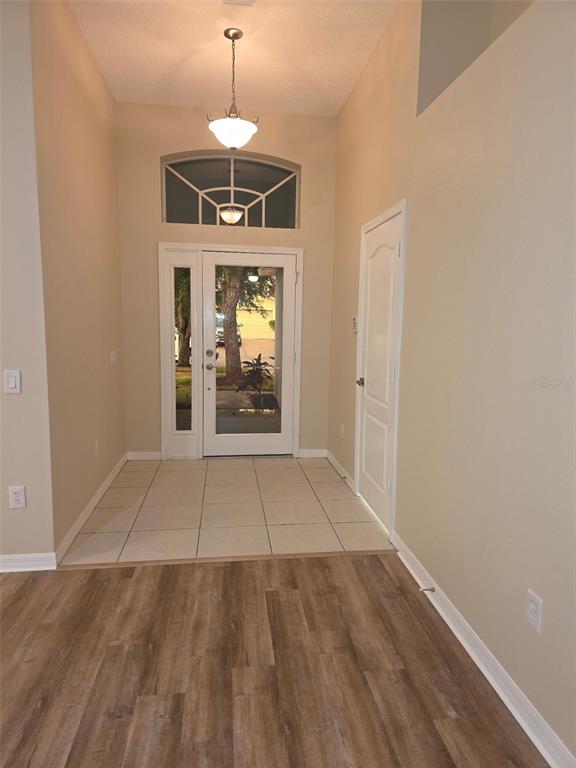 An entryway features a tiled floor, a white front door with sidelights, and wood flooring — 2313 LAWRENCE HALL STREET, RUSKIN, FL