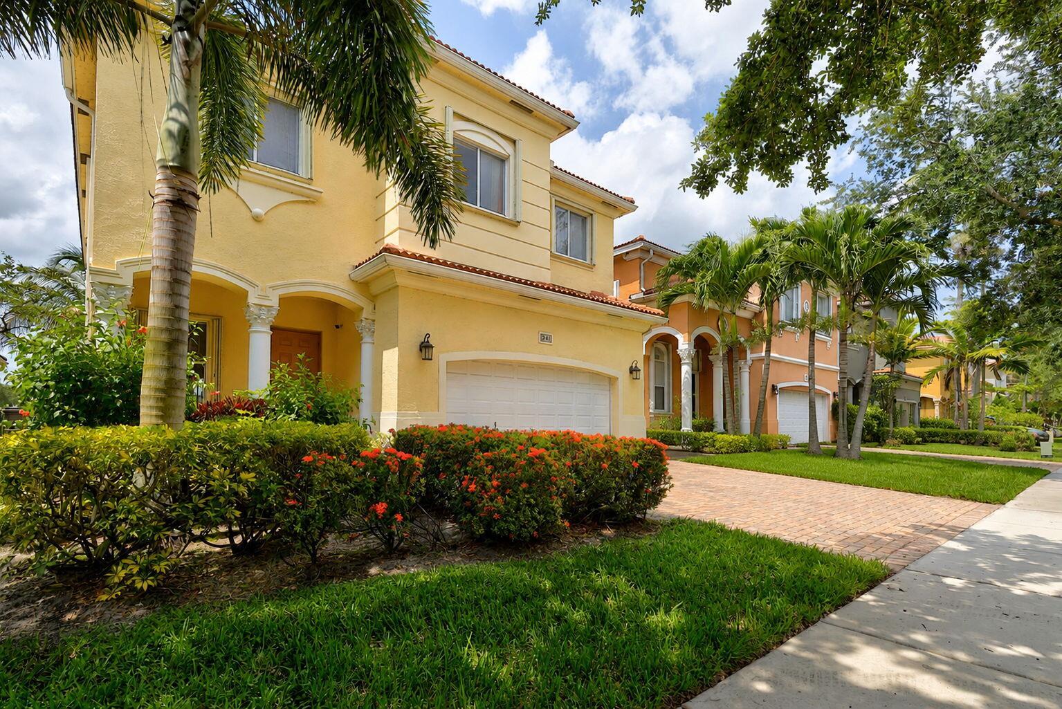 A yellow two-story house with a white garage and palm trees in the front yard — 241 Gazetta Way, West Palm Beach FL 33413, WEST PALM BEACH, FL