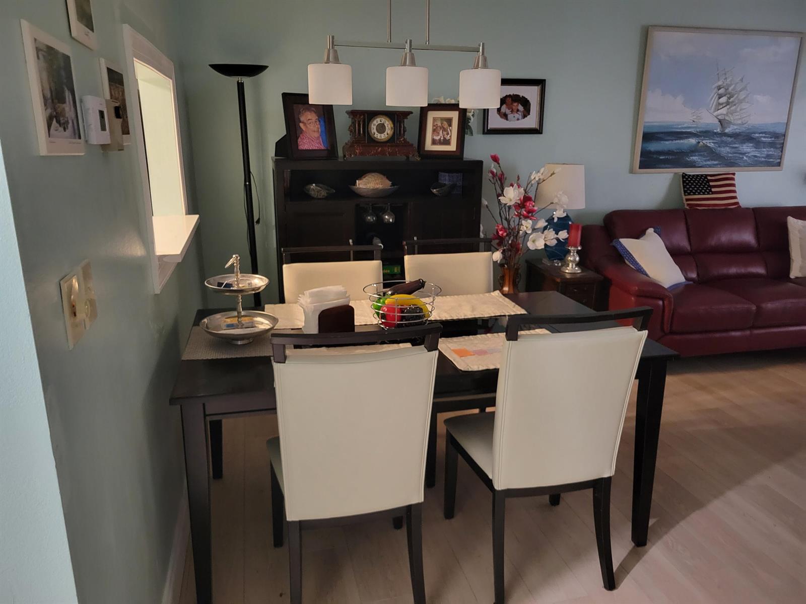 A dining area features a dark wood table, four white chairs, and a matching hutch — 700 Lori Drive # 203, Palm Springs FL 33461, PALM SPRINGS, FL