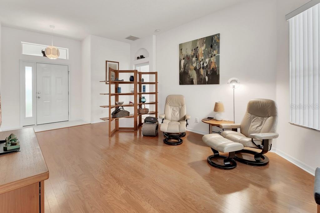 A living room with hardwood floors, two leather recliners, and a wooden shelving unit — 1483 W SILVER HAMMOCK, DELAND, FL