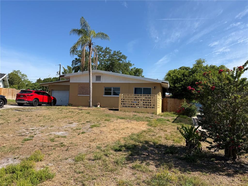 A single-story house with a yellow exterior, a concrete driveway, and a palm tree — 1330 EMILY COURT, CLEARWATER, FL