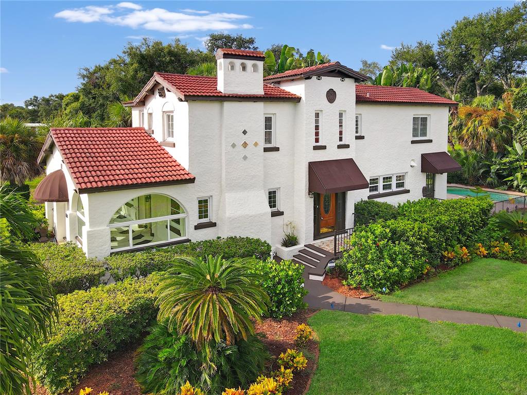 A two-story white stucco house with a red tile roof and lush landscaping — 120 PARK STREET N, ST PETERSBURG, FL