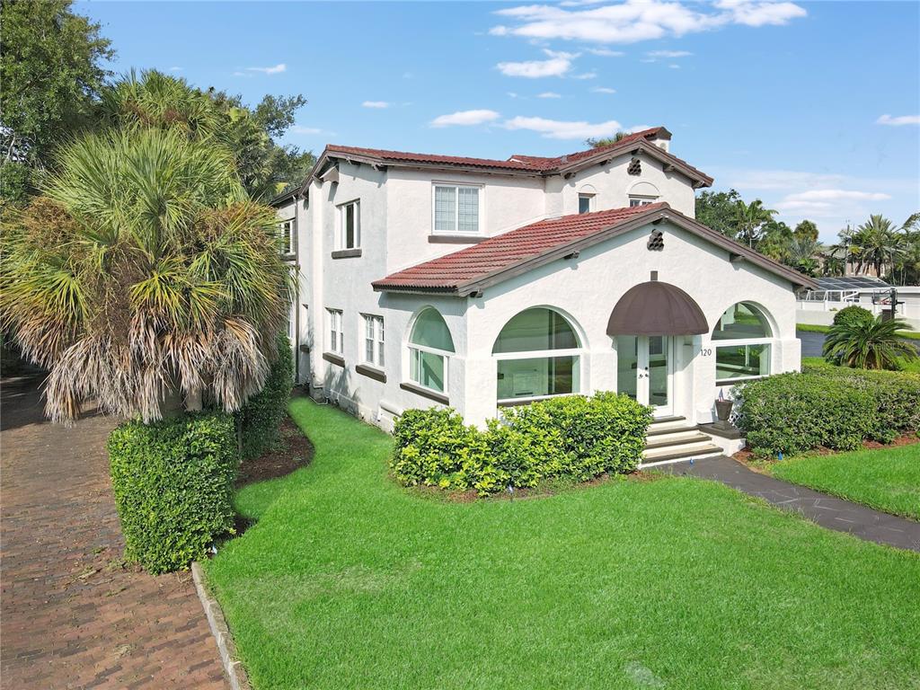A two-story white stucco house features a red tile roof and arched front windows — 120 PARK STREET N, ST PETERSBURG, FL