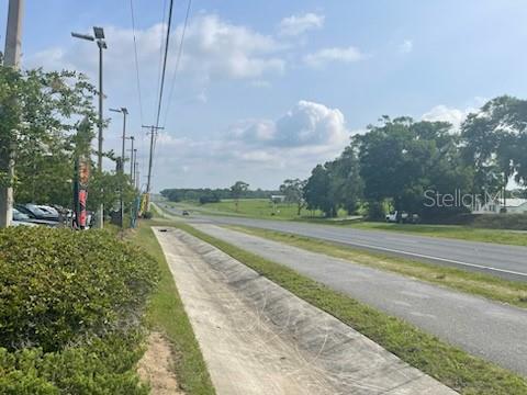A paved drainage ditch runs alongside a highway with trees and a grassy field nearby — 10736 US HIGHWAY 301, DADE CITY, FL
