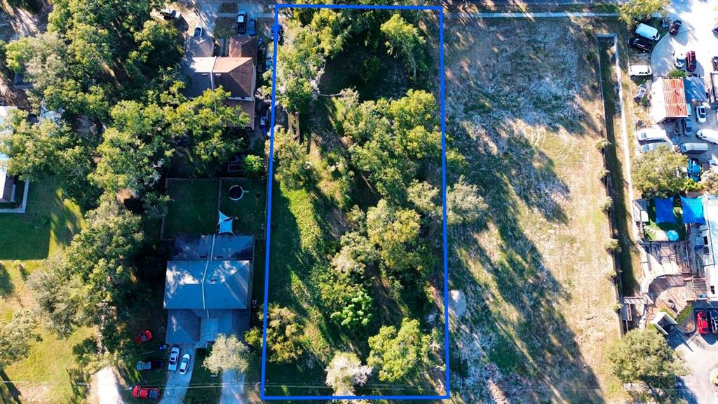 An aerial view shows a rectangular, tree-covered vacant lot outlined in blue between two properties — SAND AVENUE, APOPKA, FL
