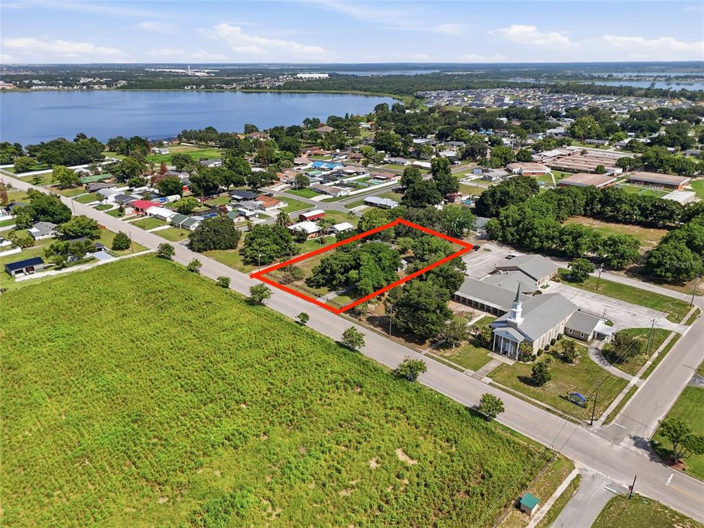 An aerial view shows a rectangular plot of land outlined in red near a church — 545 E HAINES BOULEVARD, LAKE ALFRED, FL