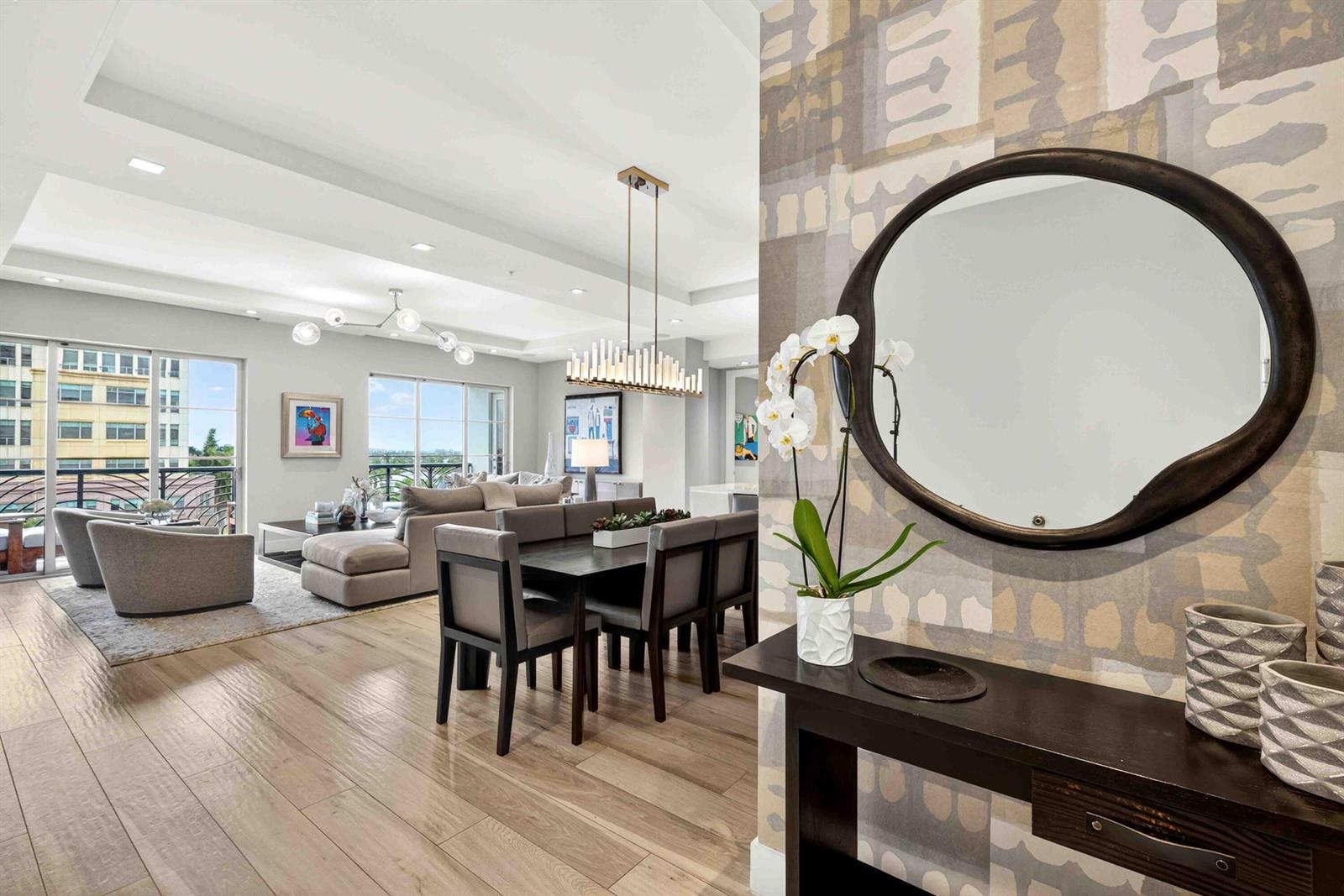 A modern dining and living area features wood floors, a chandelier, and a balcony view — 155 E Boca Raton Road # 611, Boca Raton FL 33432, BOCA RATON, FL