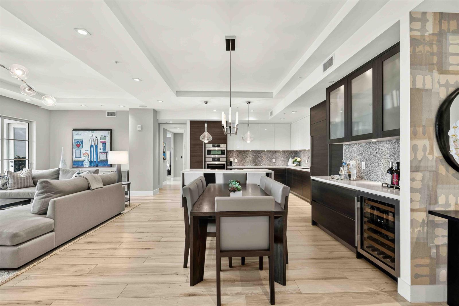 A modern open-concept living and dining area features light wood floors and dark cabinetry — 155 E Boca Raton Road # 611, Boca Raton FL 33432, BOCA RATON, FL