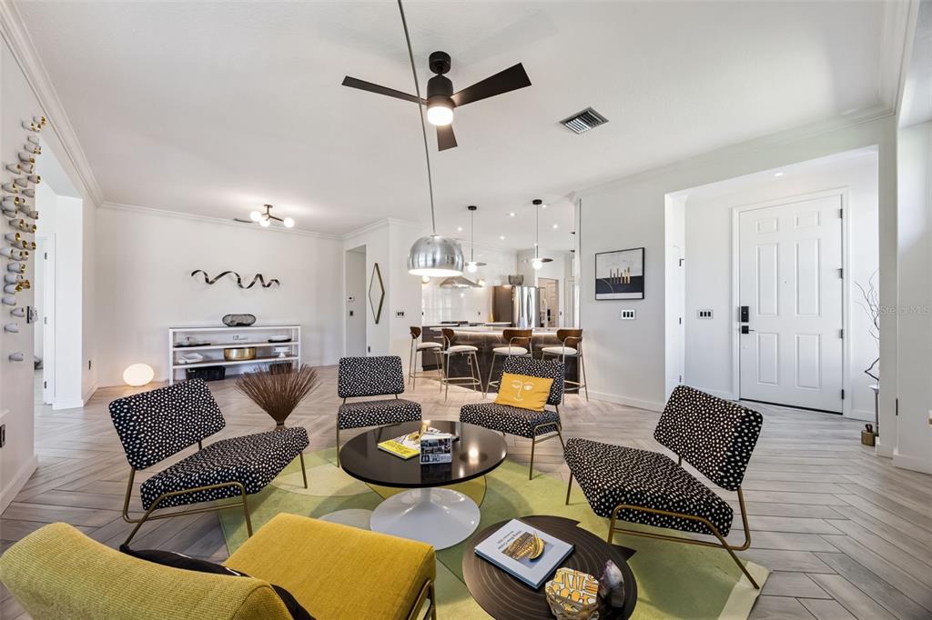 A living room features four patterned chairs, a yellow ottoman, and a central coffee table — 371 SALT MARSH LANE, GROVELAND, FL