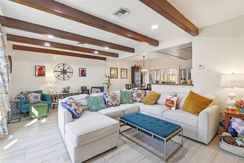 A two-story house with beige siding, a brick lower level, a garage, and a front porch — 1023 S MORNINGSIDE DRIVE, EUSTIS, FL