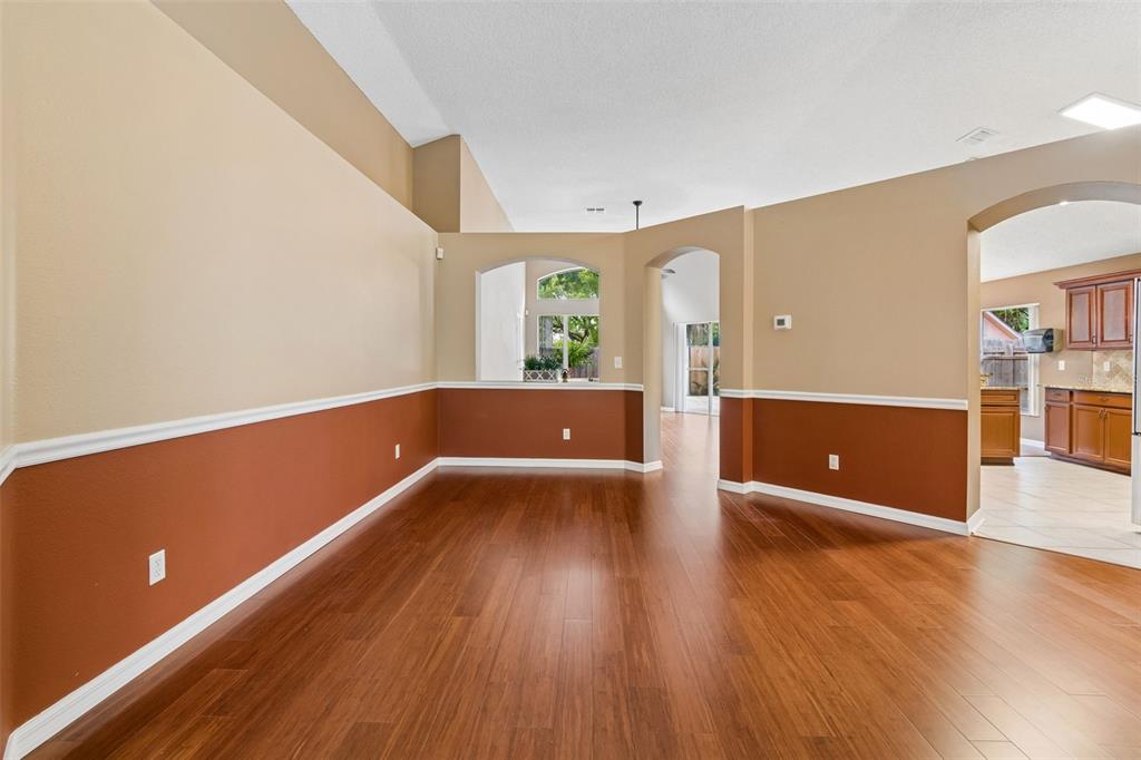 An empty room with two-tone walls, white chair rail molding, and dark wood flooring — 5646 PADDOCK TRAIL DRIVE, TAMPA, FL