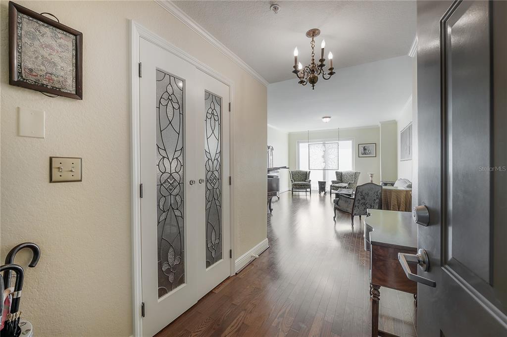 An entryway with hardwood floors leads into a living room featuring a chandelier and furniture — 700 S HARBOUR ISLAND BOULEVARD UNIT 716, TAMPA, FL