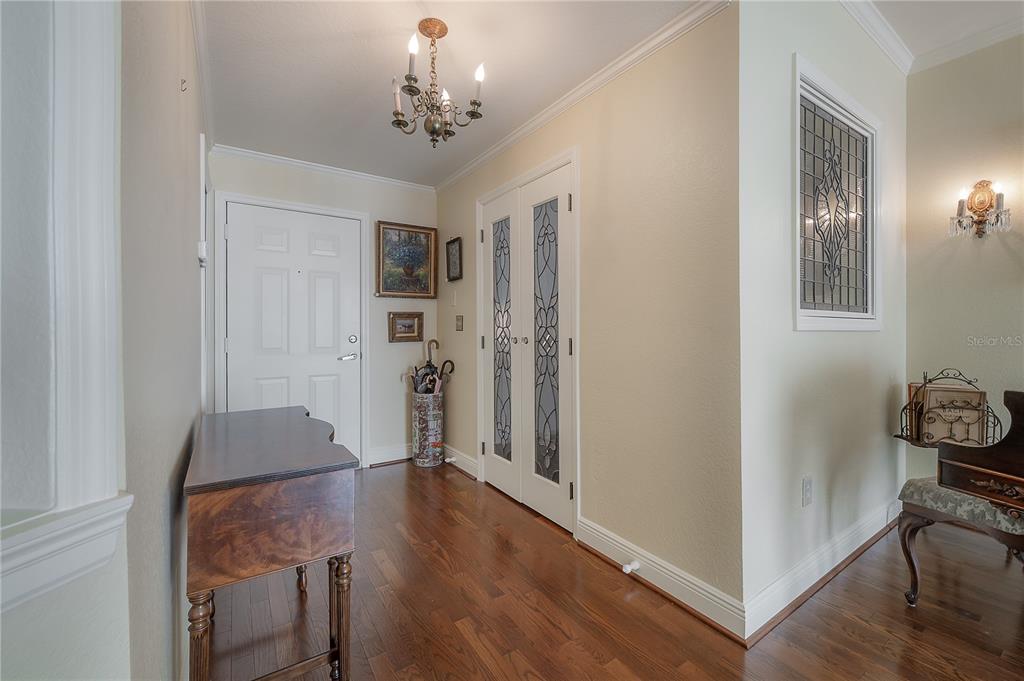 A foyer features hardwood floors, a chandelier, a white front door, and glass-paneled double doors — 700 S HARBOUR ISLAND BOULEVARD UNIT 716, TAMPA, FL