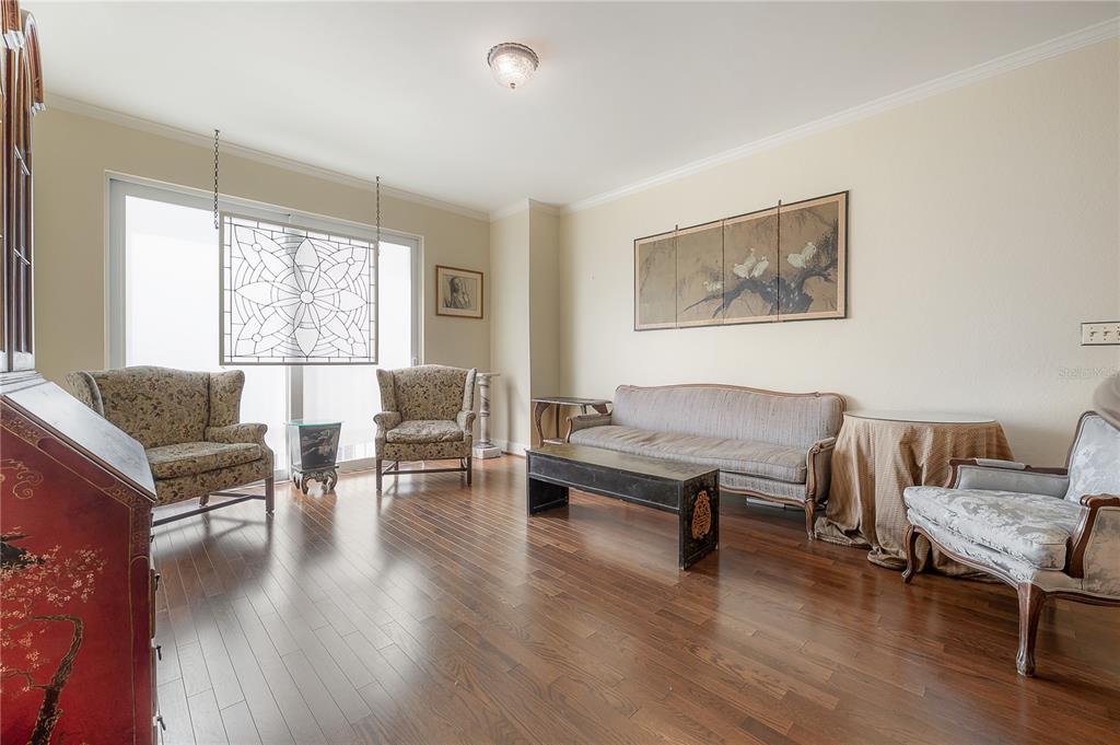 A living room features hardwood floors, a sofa, three armchairs, and a decorative hanging window panel — 700 S HARBOUR ISLAND BOULEVARD UNIT 716, TAMPA, FL