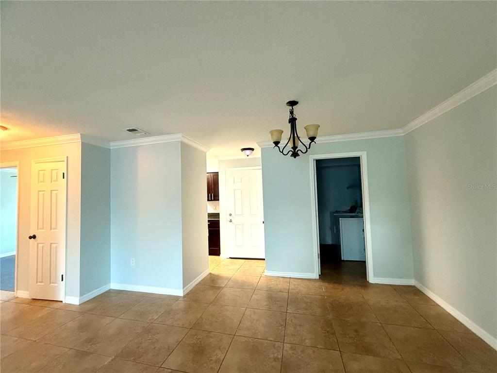 A dining area with tile flooring, a chandelier, and doorways leading to other rooms — 209 DORCHESTER SQUARE UNIT 209, LAKE MARY, FL