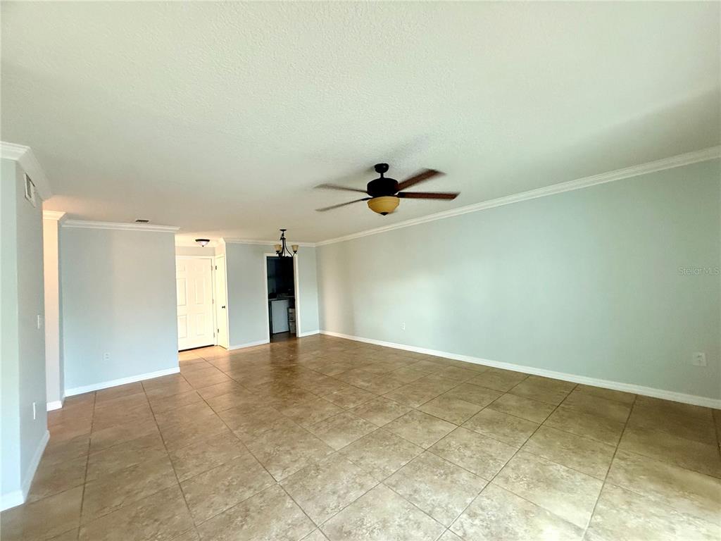 An empty room features light-colored walls, a ceiling fan, and large tan floor tiles — 209 DORCHESTER SQUARE UNIT 209, LAKE MARY, FL
