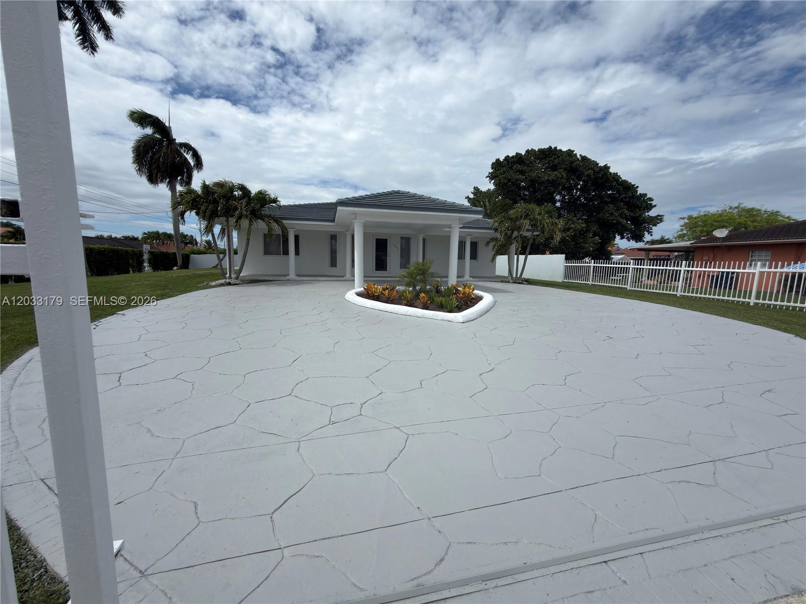 A single-story house features a large circular driveway with a central landscaped planter — 13895 SW 22nd St, Miami FL 33175, MIAMI, FL