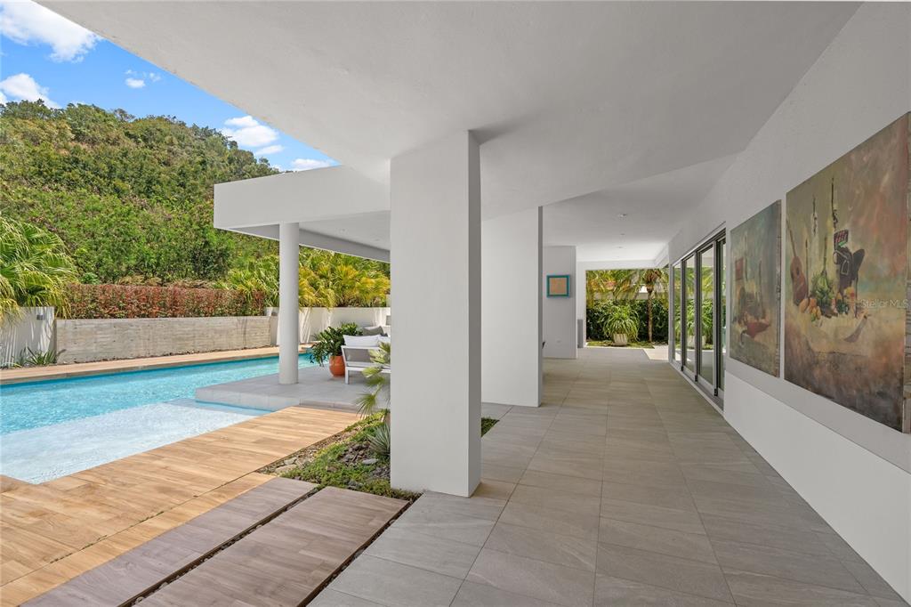A spacious living and dining area features high ceilings, tile floors, and a wooden staircase — 530 CAMINO DE GUILLARTE, DORADO, PR, PR