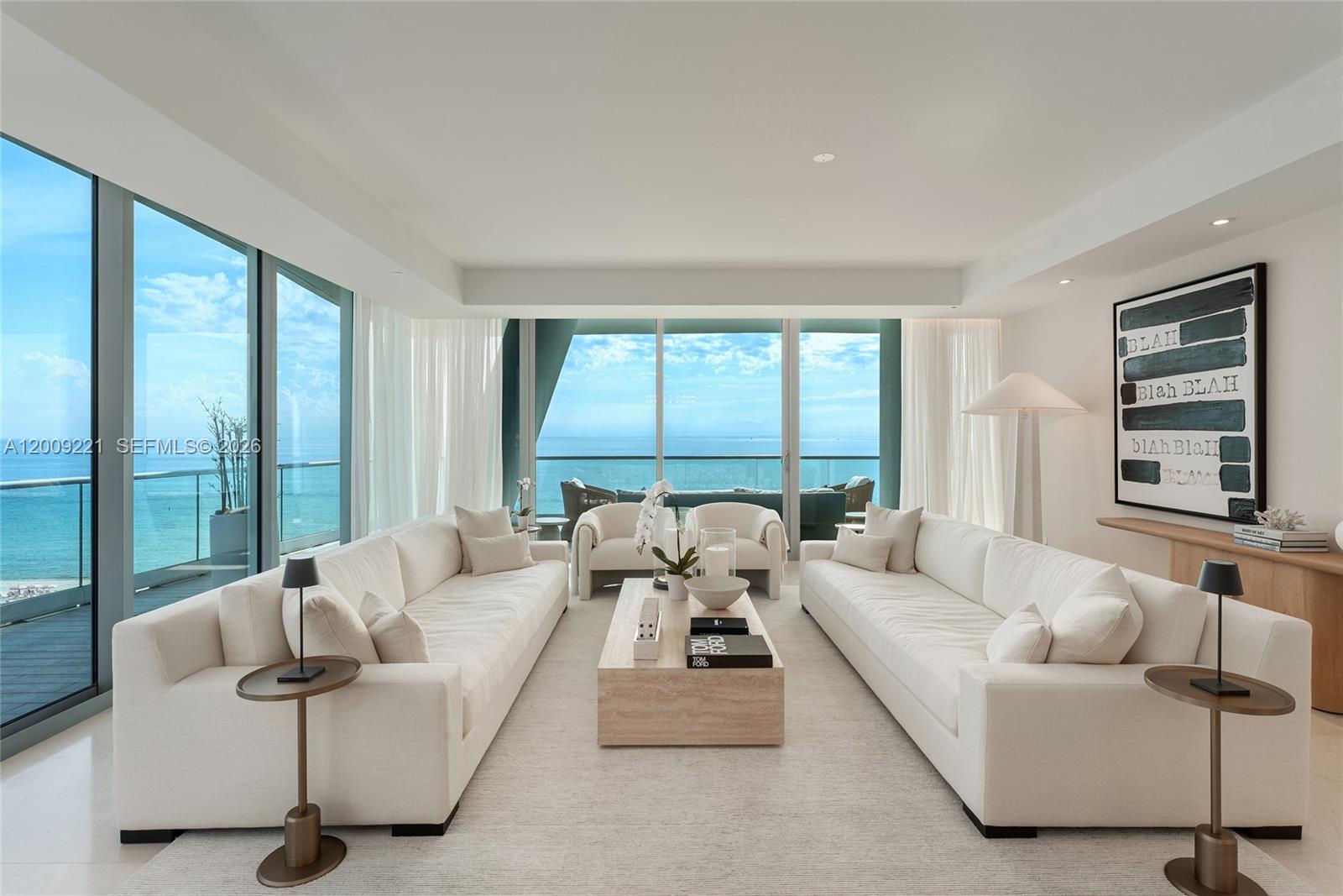 A bright living room features two white sofas, a coffee table, and floor-to-ceiling ocean views — 9349 Collins Ave # 801, Surfside FL 33154, SURFSIDE, FL